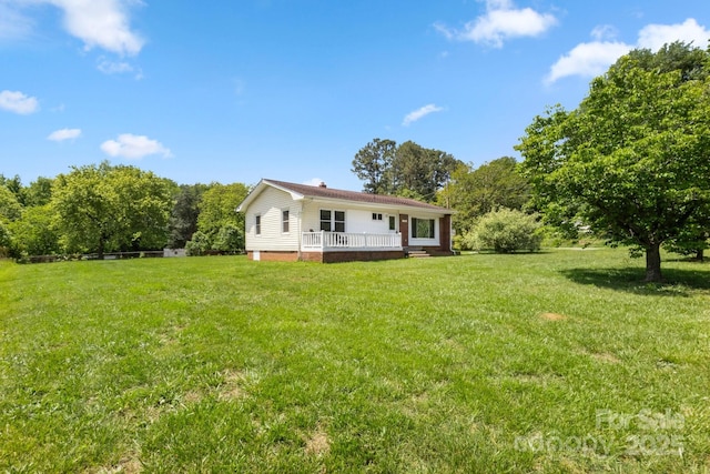 rear view of house featuring a yard and a deck