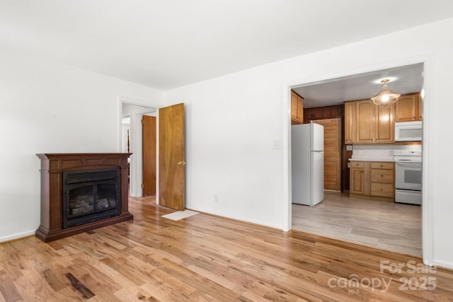unfurnished living room featuring light wood-style floors, a fireplace, and baseboards