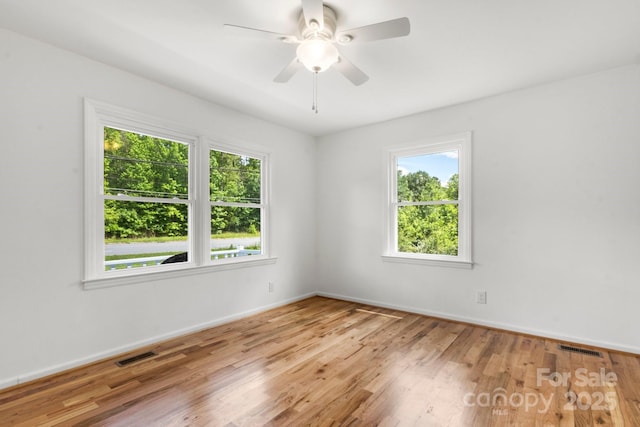 unfurnished room with wood finished floors, baseboards, and a ceiling fan