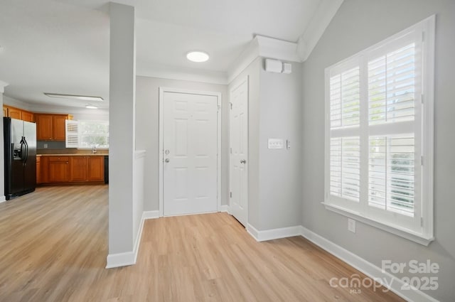 foyer entrance featuring light wood-type flooring and baseboards