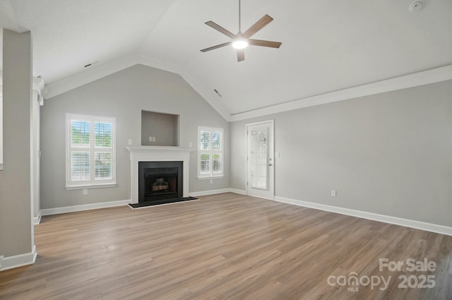 unfurnished living room featuring a ceiling fan, a fireplace, lofted ceiling, light wood finished floors, and baseboards