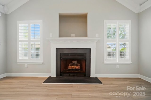 detailed view of wood finished floors, a fireplace with flush hearth, and baseboards