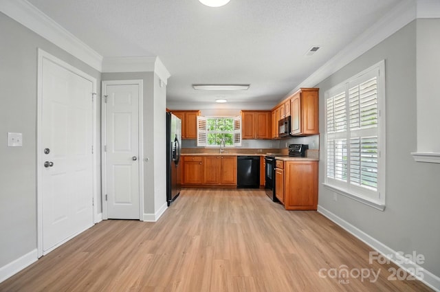 kitchen featuring black appliances, light wood finished floors, ornamental molding, brown cabinets, and baseboards