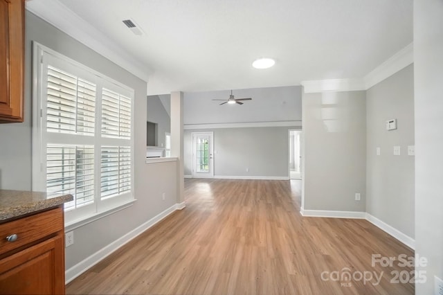 spare room with a ceiling fan, light wood-style floors, baseboards, and crown molding
