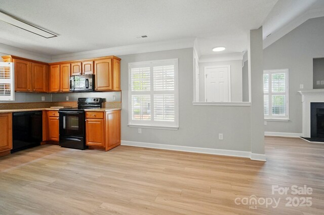kitchen featuring black appliances, light wood finished floors, baseboards, and crown molding