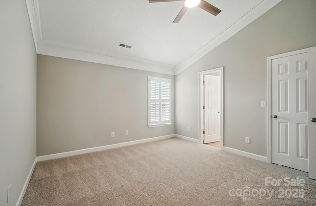 unfurnished bedroom with ornamental molding, vaulted ceiling, baseboards, light colored carpet, and ceiling fan