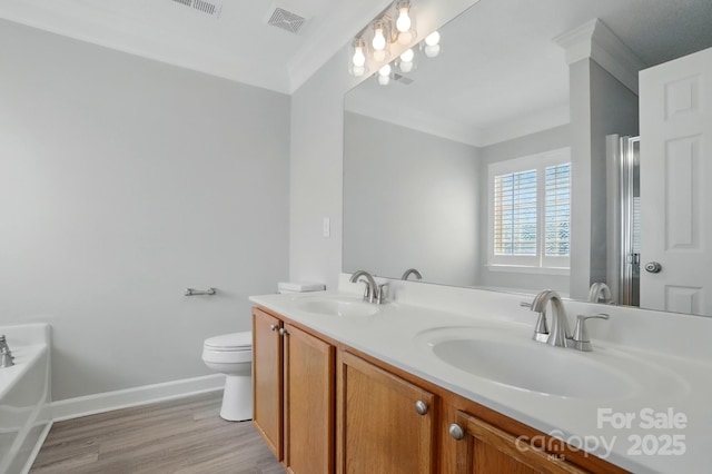 full bath with baseboards, wood finished floors, double vanity, toilet, and a garden tub