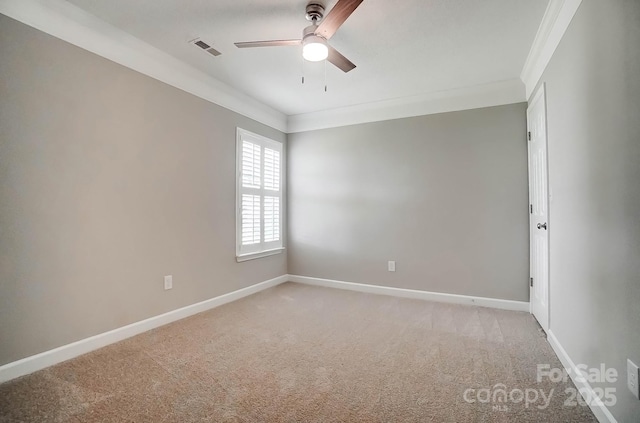 empty room with a ceiling fan, ornamental molding, light colored carpet, and baseboards