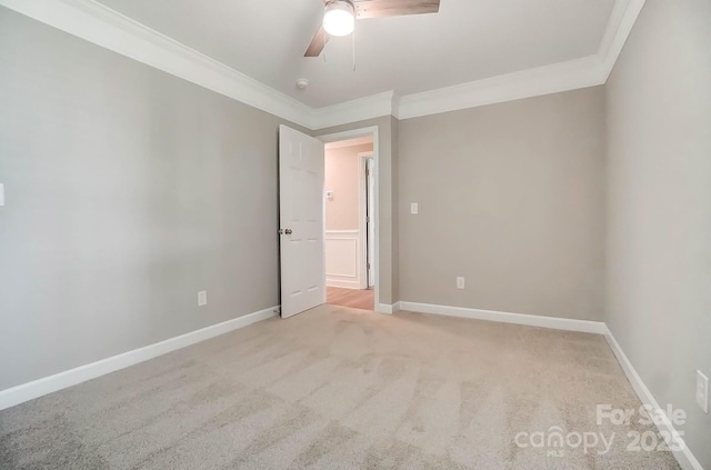 carpeted spare room with ornamental molding, ceiling fan, and baseboards