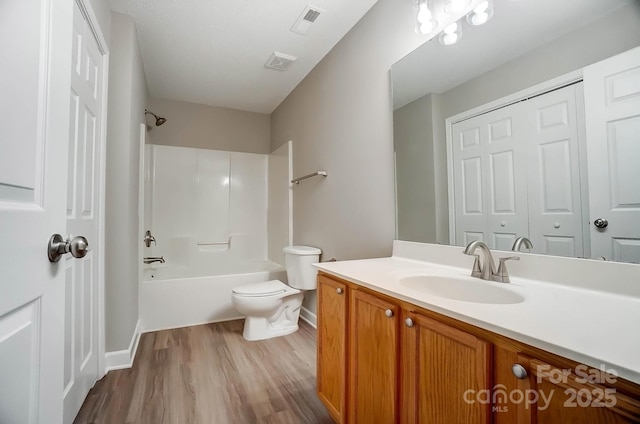 full bathroom with toilet, wood finished floors, vanity, shower / bath combination, and baseboards