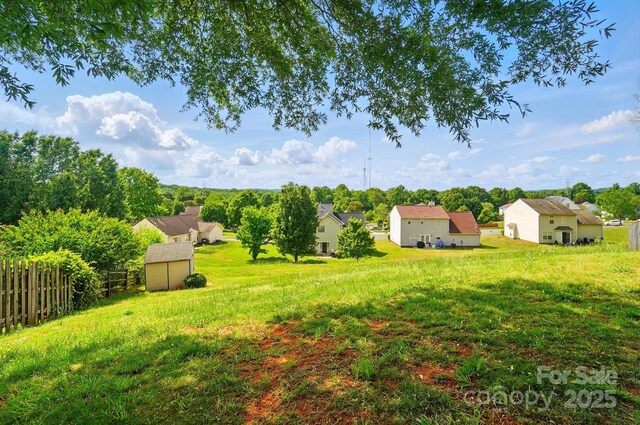 view of yard with a storage shed, an outbuilding, and a residential view