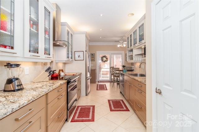kitchen featuring a ceiling fan, light tile patterned floors, ornamental molding, wall chimney exhaust hood, and stainless steel appliances