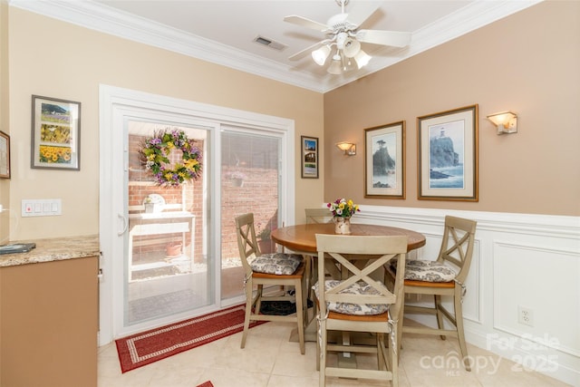 dining space with crown molding, light tile patterned floors, visible vents, and ceiling fan
