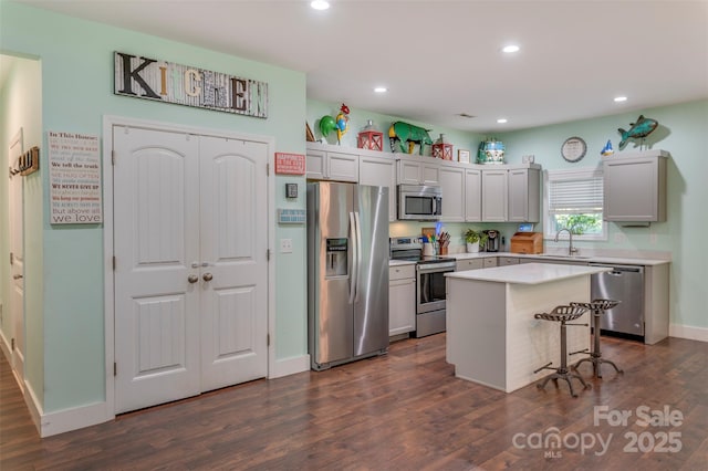 210 Holmes Dr, Spartanburg, SC 29303 - kitchen with appliances with stainless steel finishes, dark wood-style flooring, recessed lighting, light countertops, and a kitchen breakfast bar