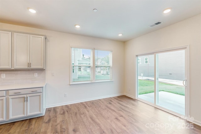 unfurnished dining area featuring light wood-style floors, visible vents, baseboards, and recessed lighting