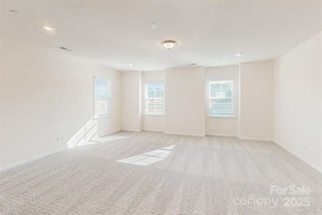 spare room featuring baseboards, recessed lighting, visible vents, and light colored carpet