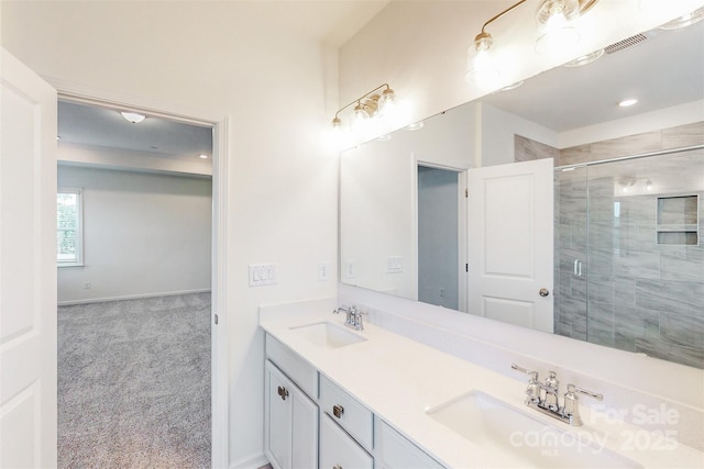 full bathroom featuring a sink, double vanity, a stall shower, and baseboards