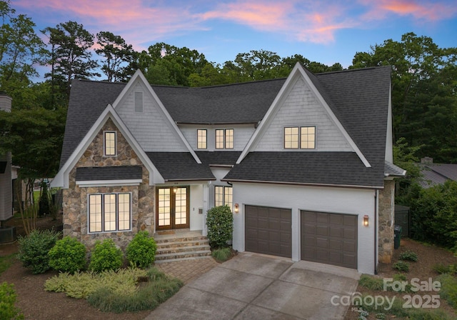 400 Hunter Ln, Charlotte, NC 28211 - view of front of house featuring stone siding, french doors, driveway, a shingled roof, and a garage