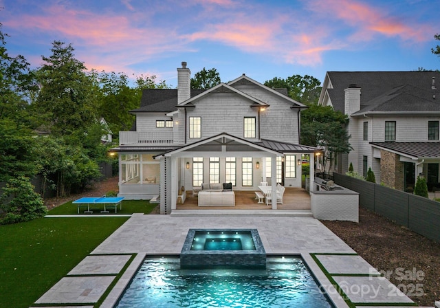 400 Hunter Ln, Charlotte, NC 28211 - rear view of property with a standing seam roof, an in-ground hot tub, a chimney, a balcony, and an outdoor pool
