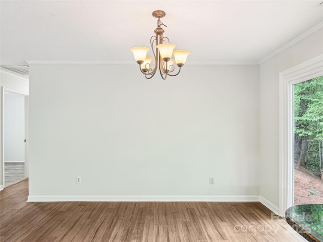 empty room with baseboards, a notable chandelier, ornamental molding, and light wood-type flooring