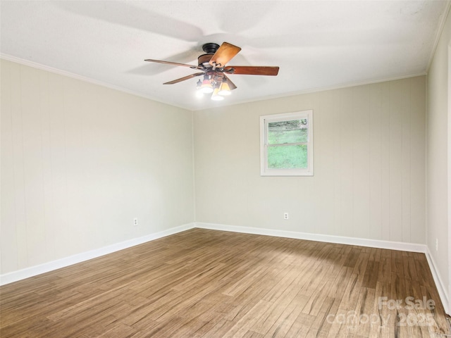 empty room featuring a ceiling fan, baseboards, crown molding, and wood finished floors