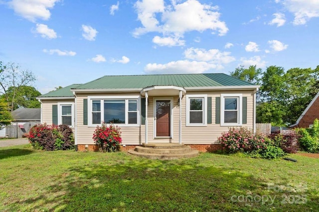 bungalow-style house with a front yard and metal roof