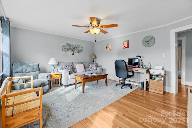 office featuring baseboards, light wood-style flooring, a ceiling fan, and ornamental molding
