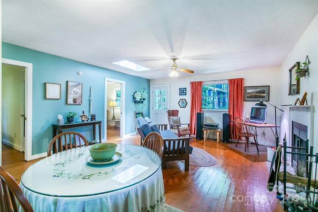 70 Lake Sega Cir, Brevard, NC 28712 - dining area featuring wood finished floors, a skylight, a ceiling fan, a textured ceiling, and baseboards