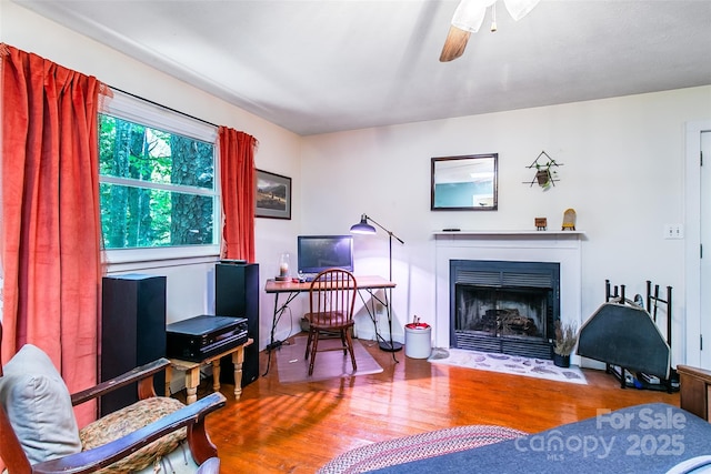 70 Lake Sega Cir, Brevard, NC 28712 - sitting room with wood finished floors, a fireplace with flush hearth, and a ceiling fan