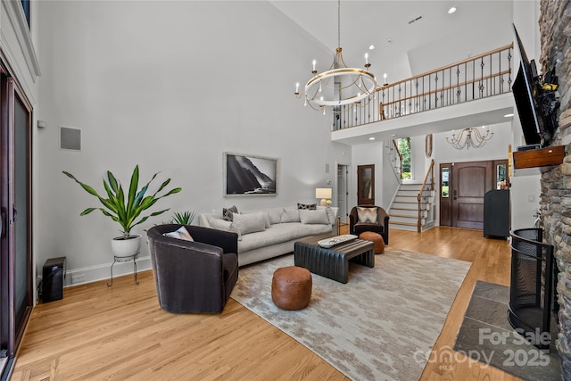 19614 Meta Rd, Cornelius, NC 28031 - living room featuring a towering ceiling, wood finished floors, a chandelier, stairway, and baseboards