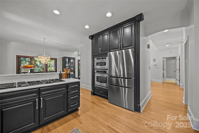 19614 Meta Rd, Cornelius, NC 28031 - kitchen with stainless steel appliances, dark cabinetry, crown molding, recessed lighting, and light wood finished floors