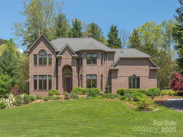 traditional home with a front lawn and brick siding