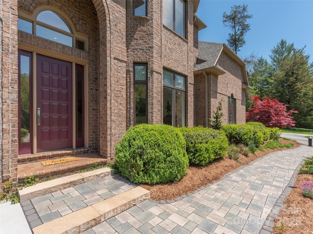 view of exterior entry featuring brick siding