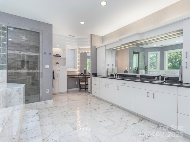 bathroom with marble finish floor, recessed lighting, a healthy amount of sunlight, and a tile shower