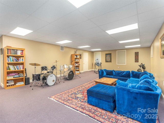 living room with carpet, baseboards, visible vents, and a drop ceiling