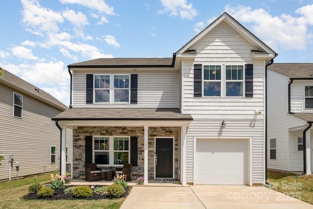 view of front of home with driveway, covered porch, a garage, stone siding, and roof with shingles