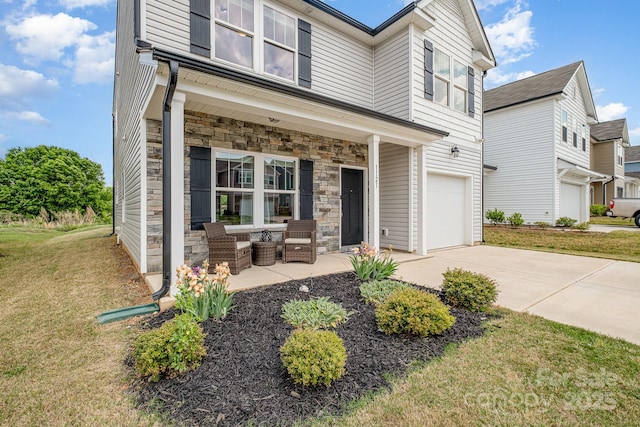 view of front of property featuring stone siding, a front yard, driveway, and a garage