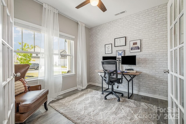 home office with brick wall, ceiling fan, and wood finished floors