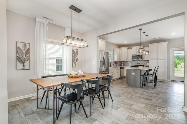 dining space featuring baseboards, recessed lighting, light wood-style flooring, and visible vents
