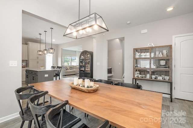 dining area with baseboards, light wood-style floors, and recessed lighting