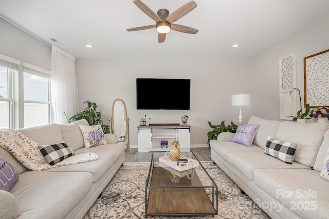 living room featuring a ceiling fan, baseboards, light wood-style flooring, and recessed lighting