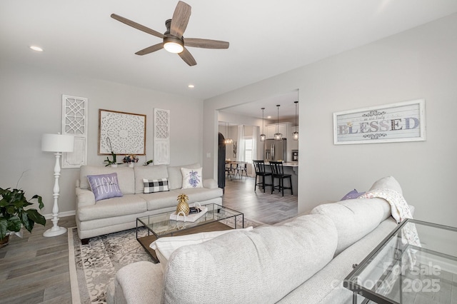living area featuring ceiling fan, recessed lighting, baseboards, and wood finished floors