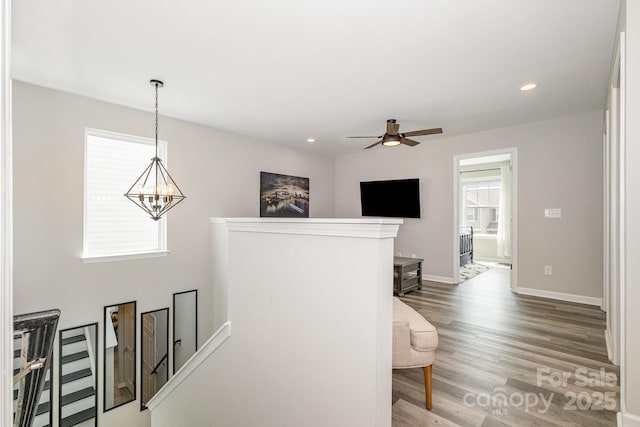corridor featuring a chandelier, recessed lighting, an upstairs landing, and wood finished floors