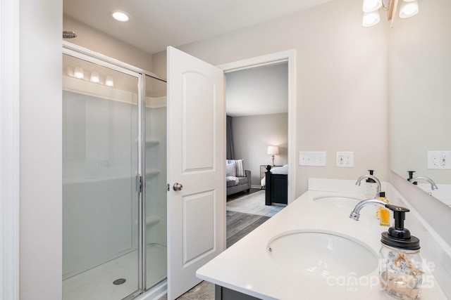 bathroom with connected bathroom, a shower stall, and a sink