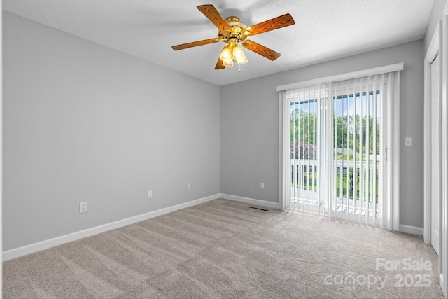 empty room with ceiling fan, carpet floors, baseboards, and visible vents