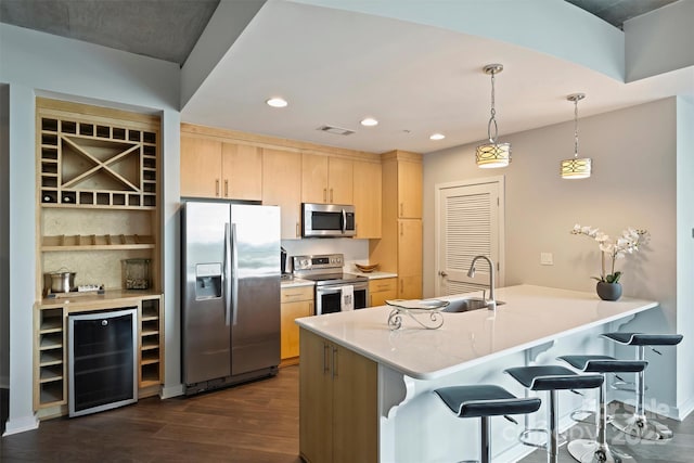 kitchen featuring appliances with stainless steel finishes, wine cooler, light brown cabinetry, a sink, and dark wood-style flooring