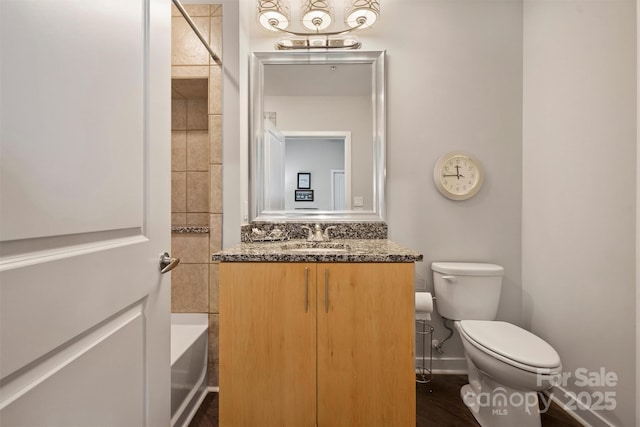 full bathroom featuring toilet, vanity, baseboards, and tub / shower combination