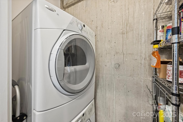 clothes washing area featuring stacked washer / dryer