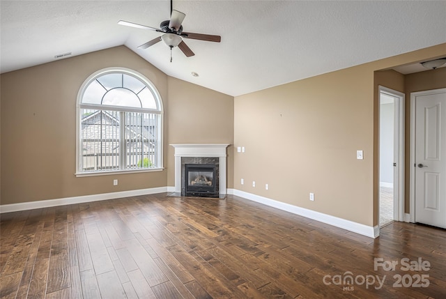 33 Braeburn Way, Flat Rock, NC 28731 - unfurnished living room featuring a ceiling fan, baseboards, dark wood-type flooring, a high end fireplace, and vaulted ceiling