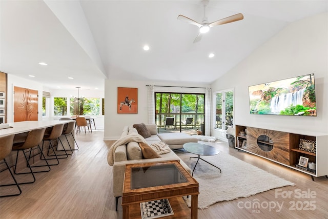 living room featuring light wood finished floors, recessed lighting, baseboards, high vaulted ceiling, and ceiling fan